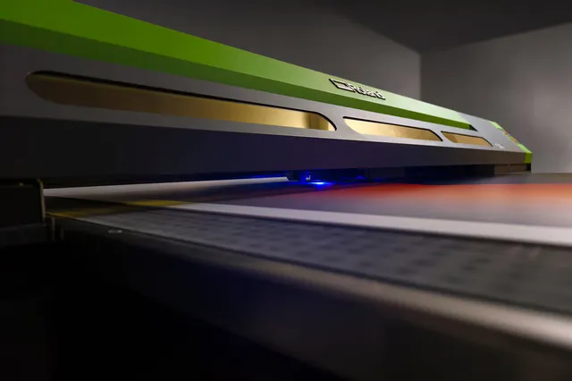 Stor grønn printer som produserer trykksak