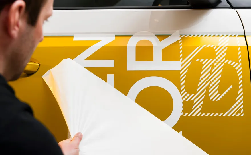 Dekor på gul bil, hvit detalj av logo